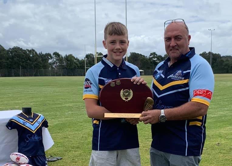 MEDAL WINNER: Beau Hill, captain of the Nelson Bay Junior Rugby League Club's under-13 side, accepts the Steve Lingard shield from club vice president Wayne Humphrey. Picture: Supplied