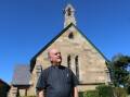 HISTORIC: St John Anglican Church's Fr Steve Niland in front of the 160 year old sandstone building in Sturgeon Street, Raymond Terrace.