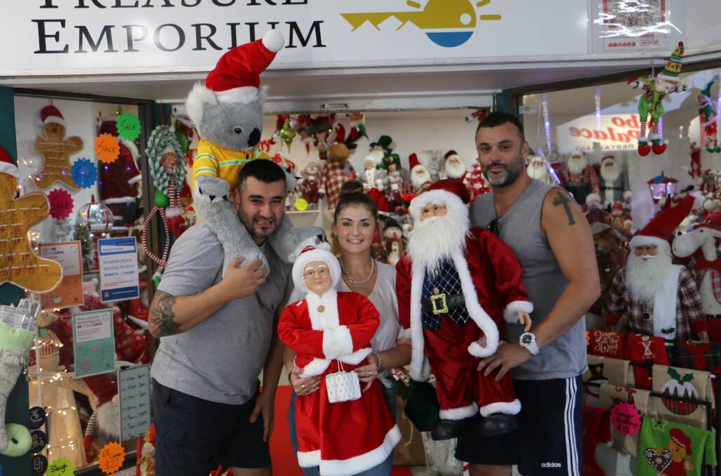 SANTA IN THE BAY: A new Christmas shop opened by cousins Andrew and Andy Papasavvas, pictured with sales assistant Logan Davidson, is giving the Bay a vibrant Christmas atmosphere.