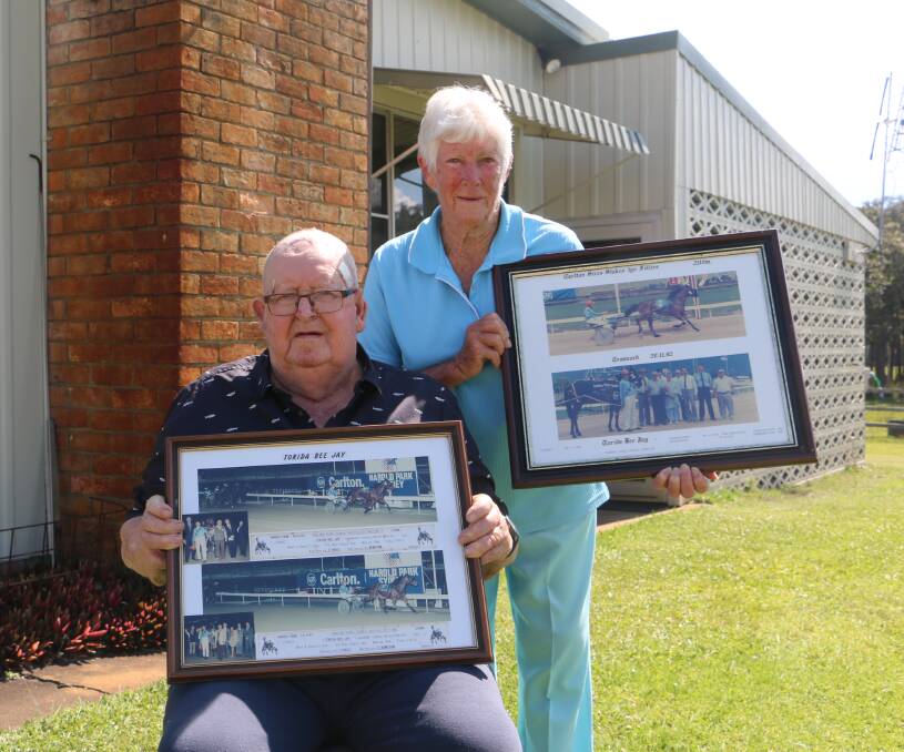 LAST FRONTIER: Tom and Joan Frost with framed photos of some of their successful pacers out the front of their Frost Road home.