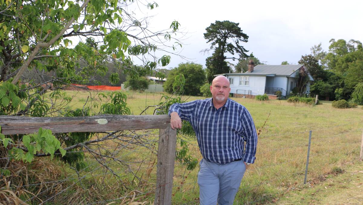 APPROVED: Cr Chris Doohan in front of the block of land fronting Medowie Road which has been approved for a commercial development. The house is to be demolished.