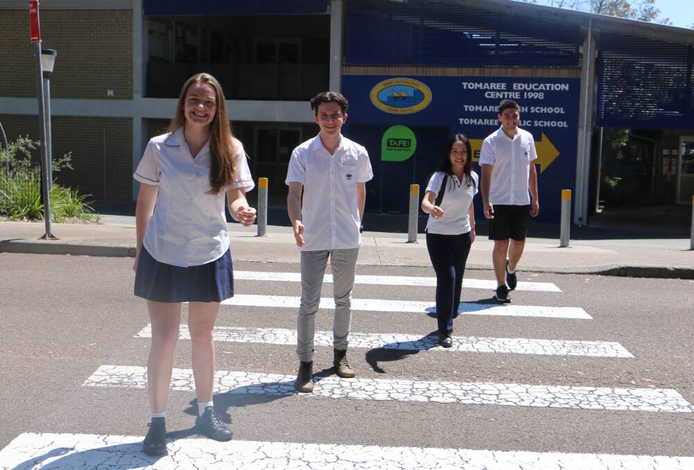 FAB FOUR: From left, Anna Mather, Carl Stewart, Dan Vu and Thomas Boehm impersonate the Beatles' Abbey Road album cover out the front of Tomaree High School after completing their HSC exams.