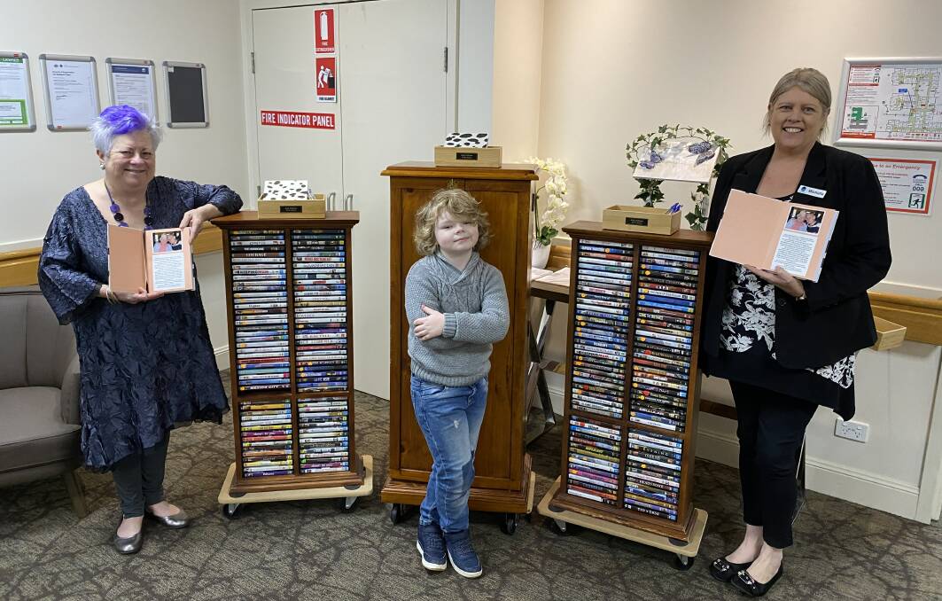 DONATION: Jan Noake (Keith's daughter), Xavier Vaughan (Keith's great grandson) and Michelle Armstrong (Opal Raymond Terrace) with the DVD collection. Picture: Supplied. 