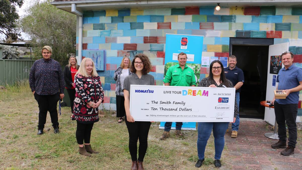PRESENTATION: Holding the $10,000 cheque are The Smith Family's Victoria Grey and Natasha Reece with representatives from Komatsu, Centre for Hope and Port Stephens Council at the Tanilba Bay facility.