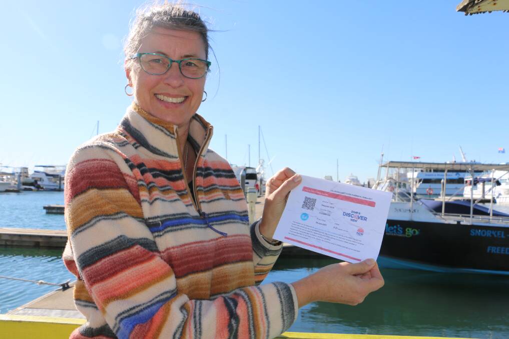 BUSY: Bay Booking Office owner Lorraine Edmund with a Dine and Discover NSW voucher, which were in use in the Port across the weekend.