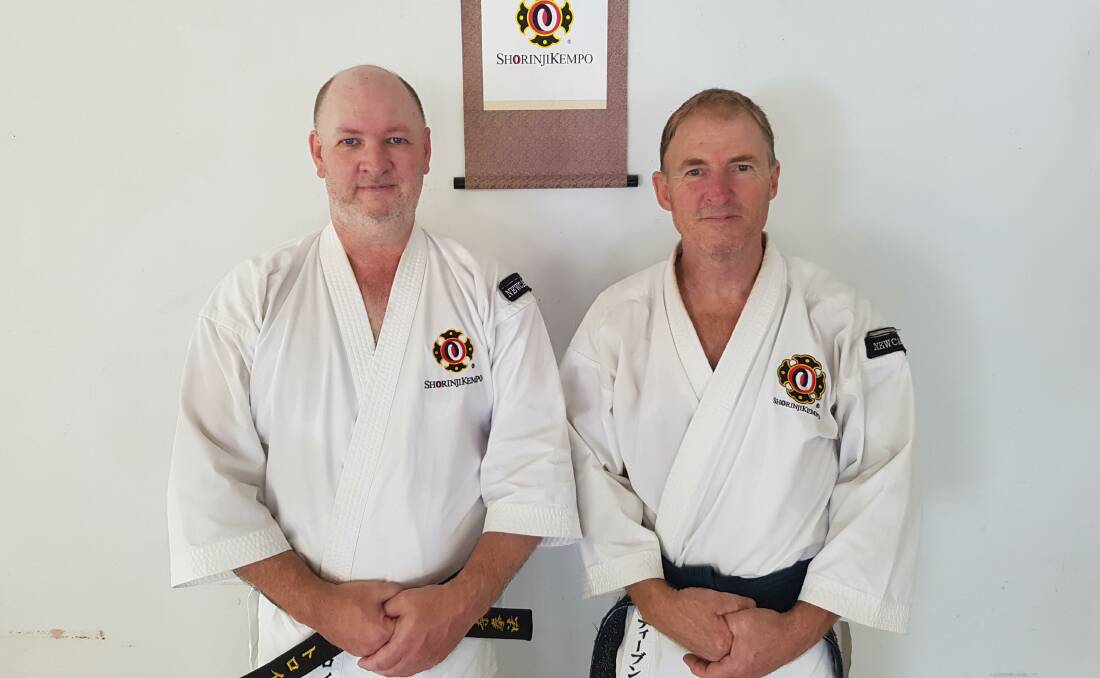 2ND DAN: Receiving his second dan black belt is Troy Cormack (left) from teacher Steven Clarke. Picture: Supplied