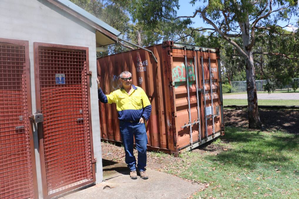 DILAPIDATED: Medowie Rugby president Dwayne Murphy next to the single male and female toilets at Boyd Oval and the small shipping container used as a store room.