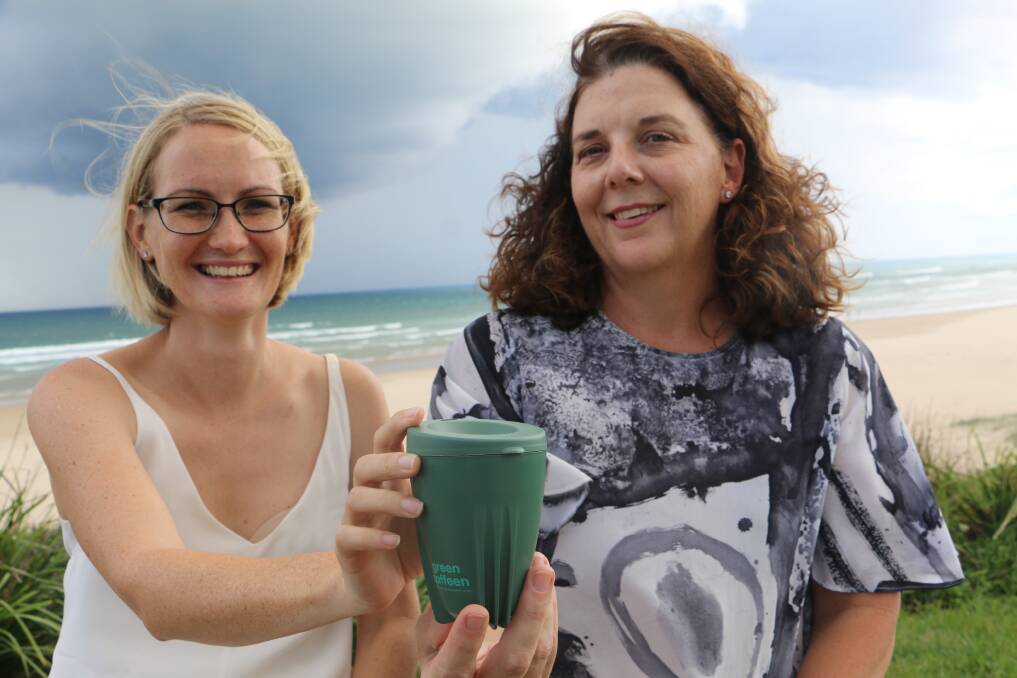 REUSABLE: The Green Caffeen 'swap & go' coffee cup displayed by 'Citizen of the Year' Alicia Cameron and Cr Sarah Smith at Birubi beach.