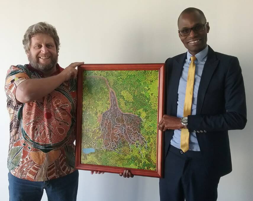 CULTURE SHARING: Peter Kafer presents his artwork to the Botswanan Acting High Commissioner Mr Kesegofetse Unoda Mazongo in Canberra. Pictured: Supplied