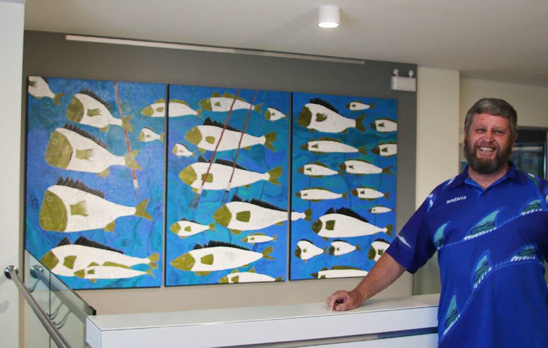 SALTWATER MAN: Aboriginal artist Peter Kafer, from Raymond Terrace, with the painting presented to Newcastle Airport recently. Picture: Supplied