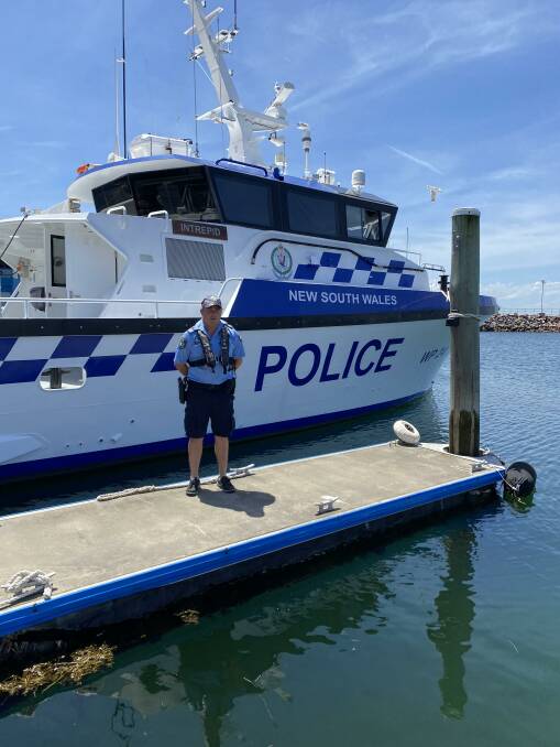 SAFETY MESSAFE: Sergeant Clint Brown in front of the Port Stephens Water Police launch Intrepid.