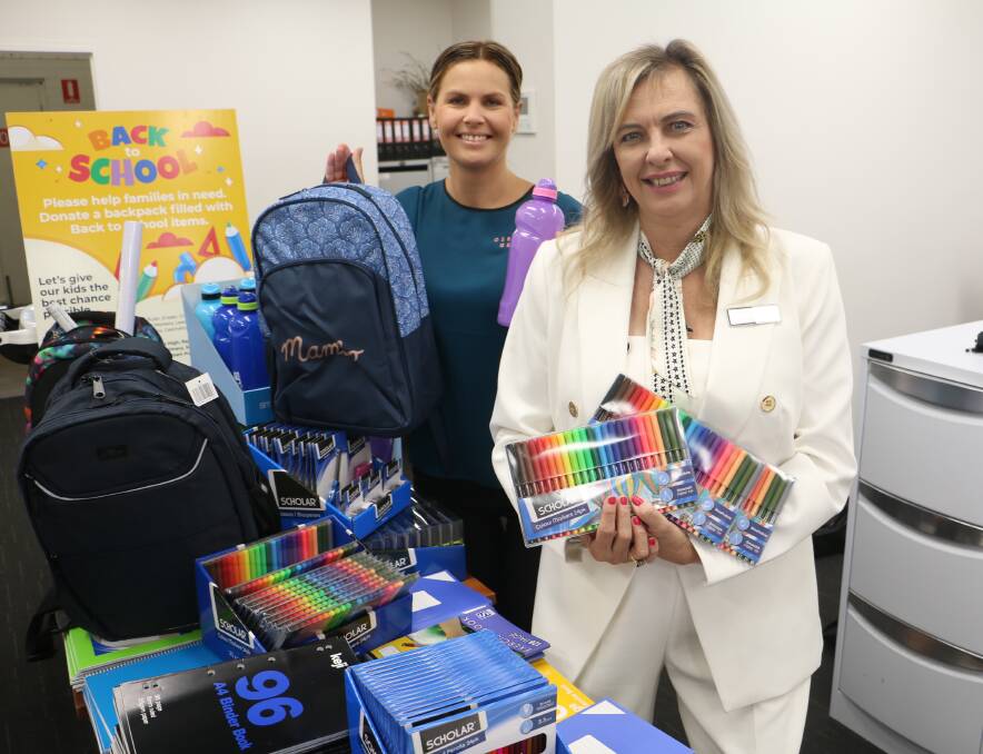 DONATED: Raymond Terrace Rotary president Tracy Jonovski (right) and Osborn George staff member and volunteer helper Keira Fox with some of the school stationery.