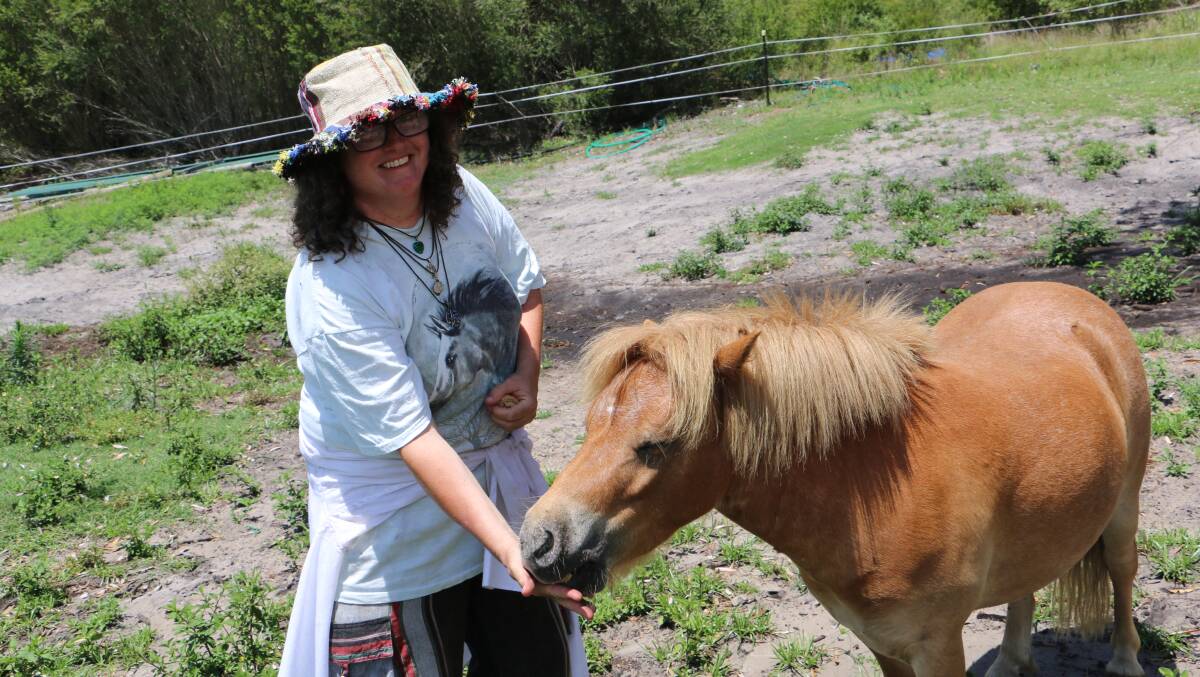Volunteer Elise Thomas feeds a Shetland pony at the Anna Bay property.