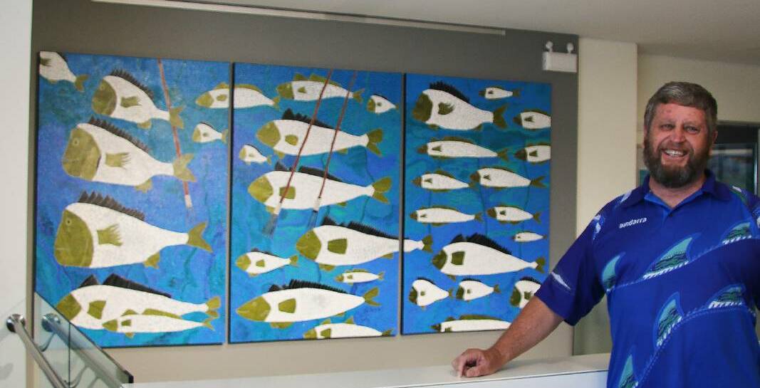 ARTIST: Peter Kafer with his painting, titled MAARA 5, which hangs in the Newcastle Airport office.