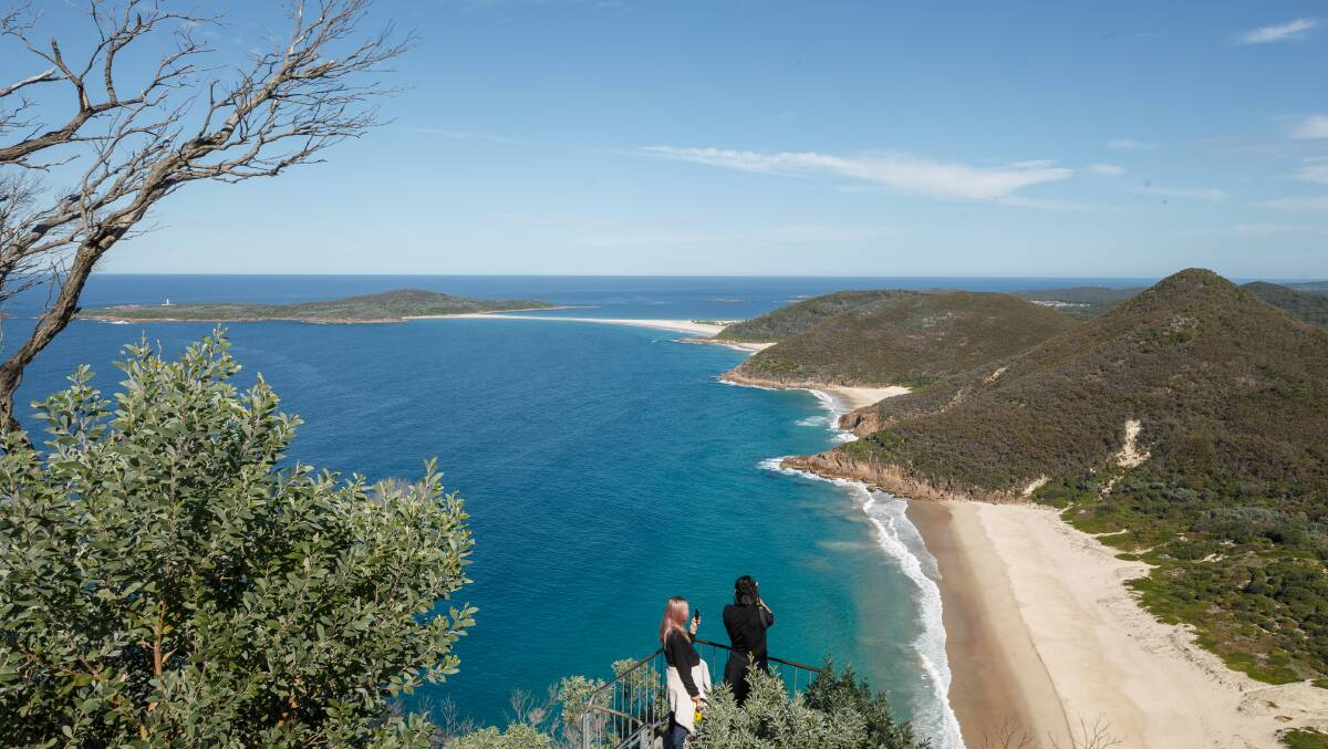 People take in the view from the top of Tomaree headland in Port Stephens. Picture: Max Mason-Hubers
