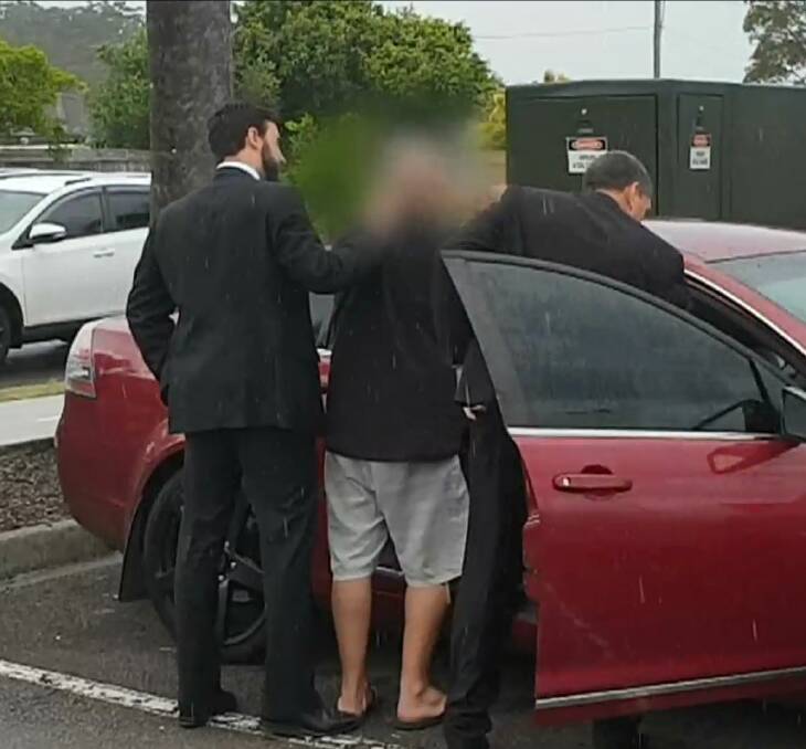 ARRESTED: Police handcuff a man, 42, at Salamander Bay on Thursday. The man is charged with use carriage service to procure person under 16 for sex and will face court on Friday. Picture: NSW Police
