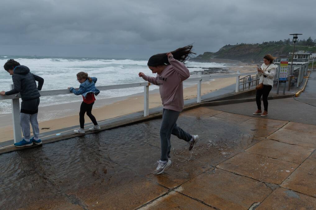 BLAST THE WEATHER: The Risorto family of Wollongong seeing the sights during a gap in the rain at Newcastle beach. Picture: Max Mason-Hubers