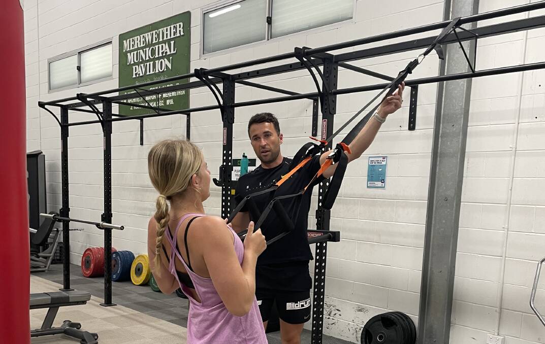 RETURN: Merewether personal trainer Scott Hingston guides Tiana Sargeant through a banded exercise.