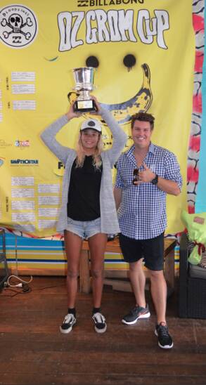 WINNER: Elle Clayton-Brown holds up the Oz Grom Cup for her victorious effort in capturing the 16-years title of the prestigious junior surfing contest in Coffs Harbour. 