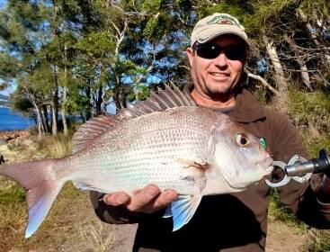 BIG RED: Shaun Miles with a 2.5 kilogram snapper caught from the rocks at Soldiers Point fishing for bream with salted white pilchards for bait. Picture: supplied.