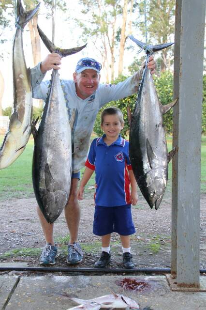 HUGE CATCH: Champion Medowie butcher and fisherman Shaun Wright, with five-year-old son Ollie, following a big day on the water. Picture: supplied.