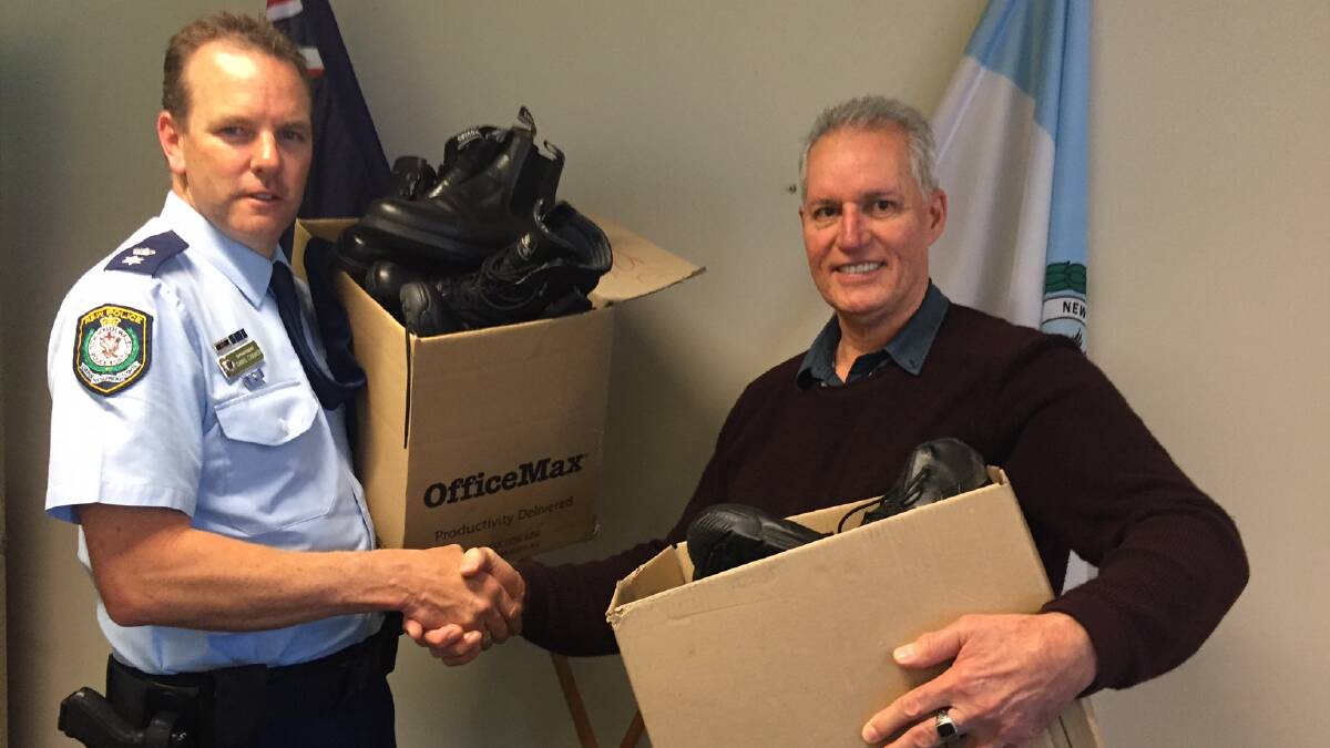 GOOD DEED: Port Stephens commander Superintendent Chris Craner with Rob Theobald from Mission Australia Newcastle collecting the box of boots on August 24. Picture: Supplied