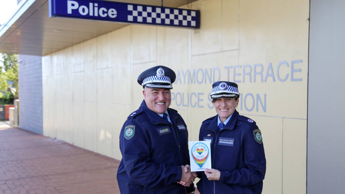 WELCOME: Port Stephens-Hunter Police District commander Superintendent Wayne Humphrey and Assistant Commissioner Gelina Talbot holding the Welcome Here sticker outside Raymond Terrace Police Station. Pictures: Ellie-Marie Watts