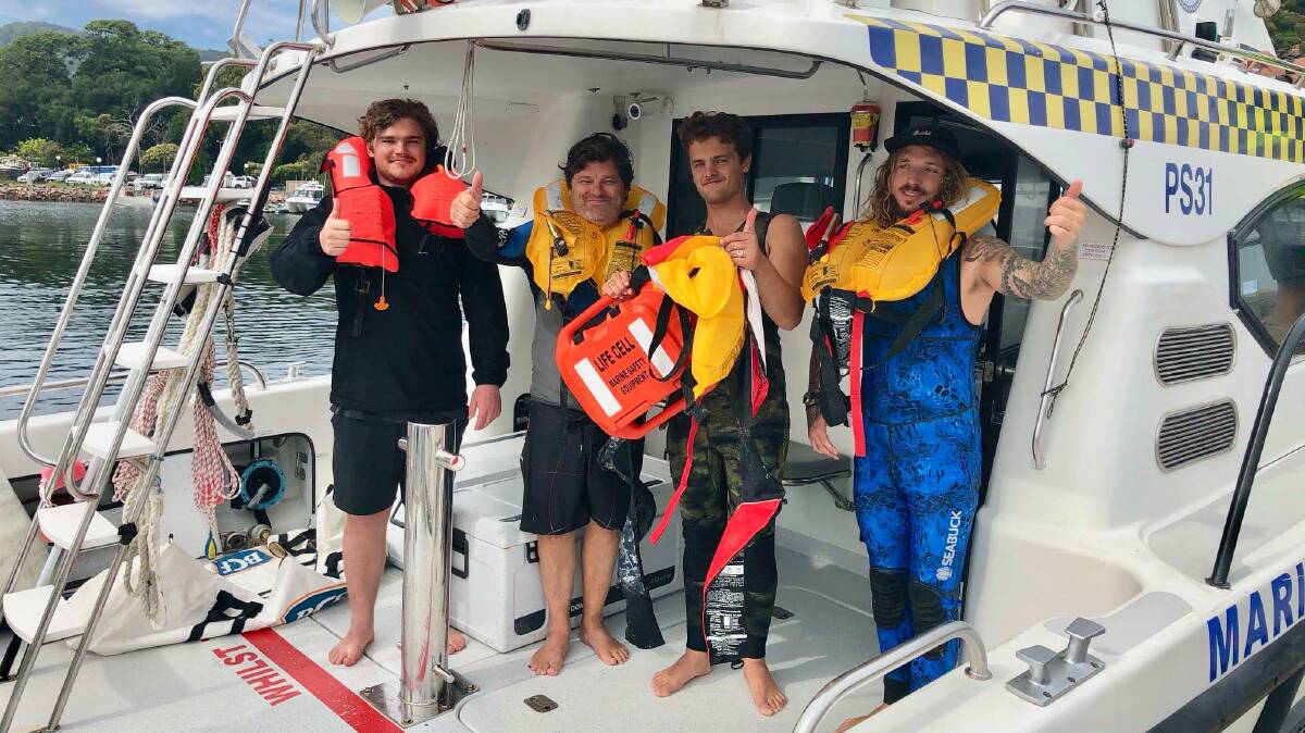 HIGH SPIRITS: Leo Hamilton, 21, Ian Hamilton, 57, Noah Hamilton, 23, and family friend Moritz, 26, on a Marine Rescue vessel on Monday. 