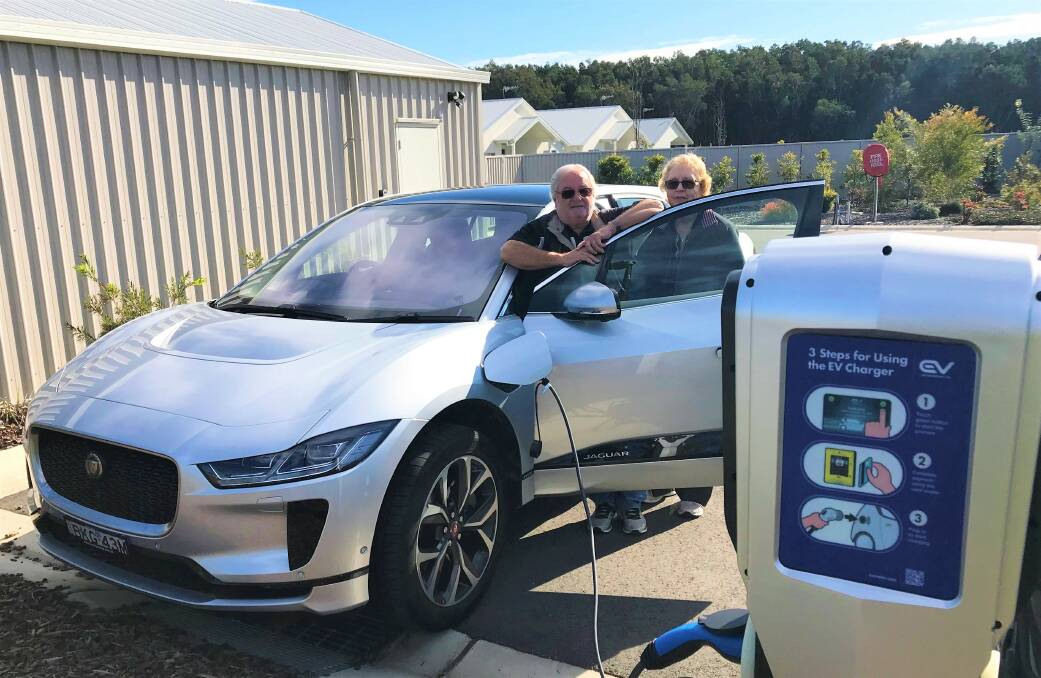 POWER UP: Latitude One residents Brian and Laura George charging their electric vehicle at the Anna Bay over-55s village. The charging station is available to the general public to use. Picture: Supplied