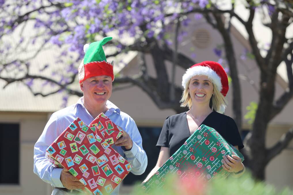 GIVING: Dowling Property Raymond Terrace directors Craig Higgins and Kate Organ in Jacaranda Avenue. The Dowling Christmas toy appeal is open until Friday, December 17. Picture: Ellie-Marie Watts