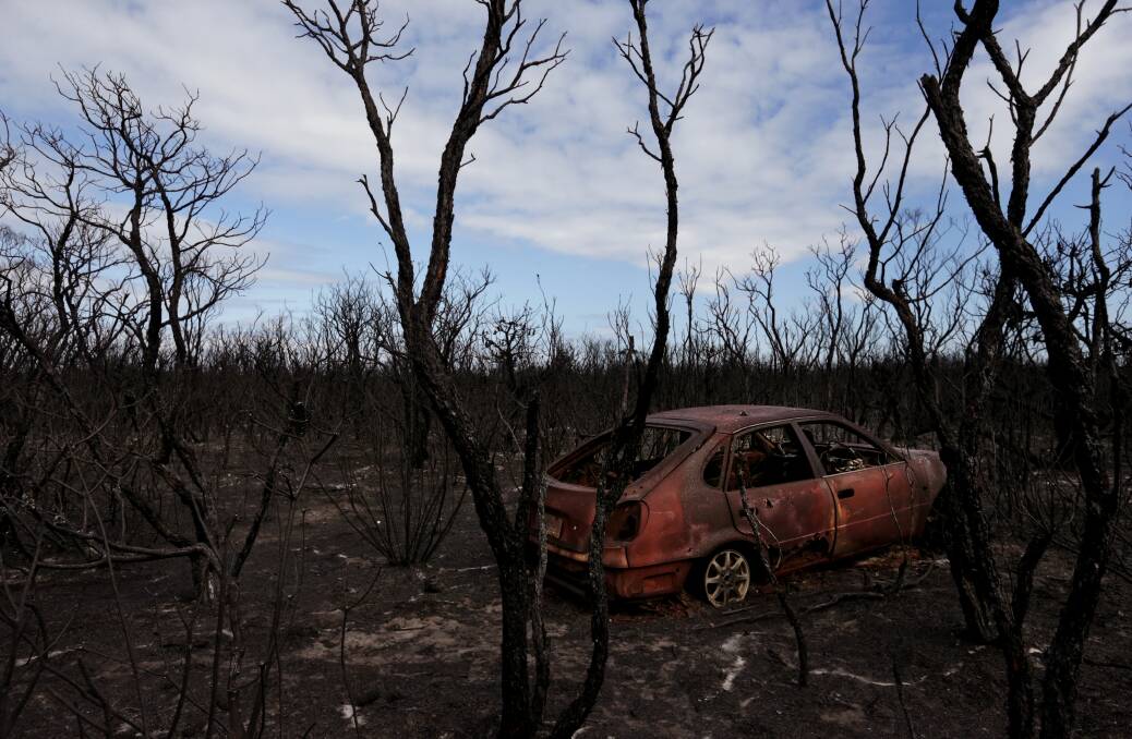 Burned bush and the body of a car behind Tilligerry Track at Tanilba Bay. Picture: Simone De Peak