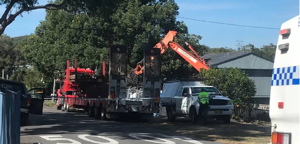 Rigney Street, Shoal Bay is closed off after an excavator has toppled off a truck.