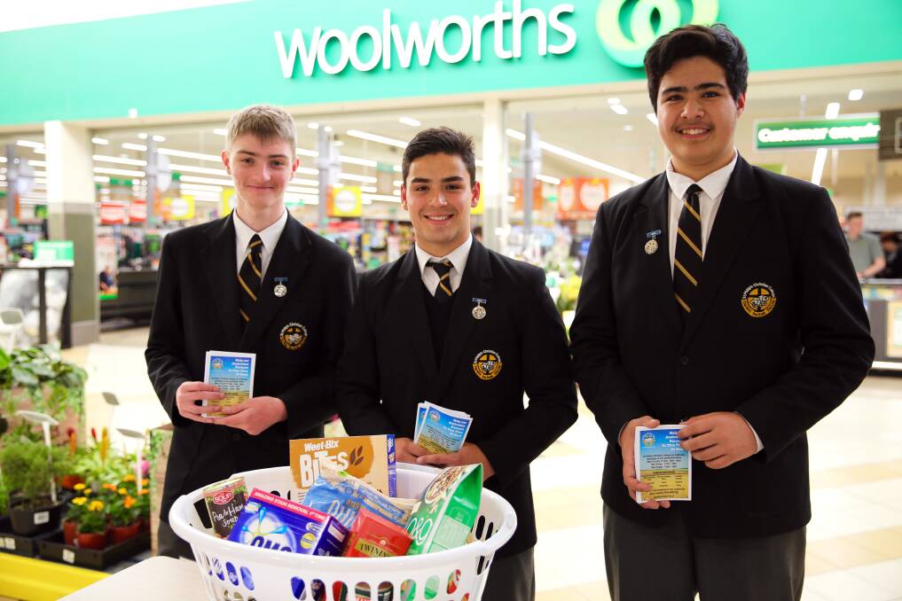Year 11 students Fletcher Gallimore, Anders Glew and Ben Brill at Salamander Bay Square on Monday. They’ve already collected around $250 in cash and four washing baskets full of groceries.