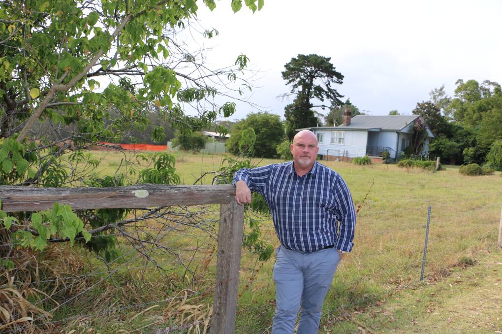 Cr Chris Doohan in front of the block of land fronting Medowie Road which has been approved for a commercial development. The house is to be demolished.