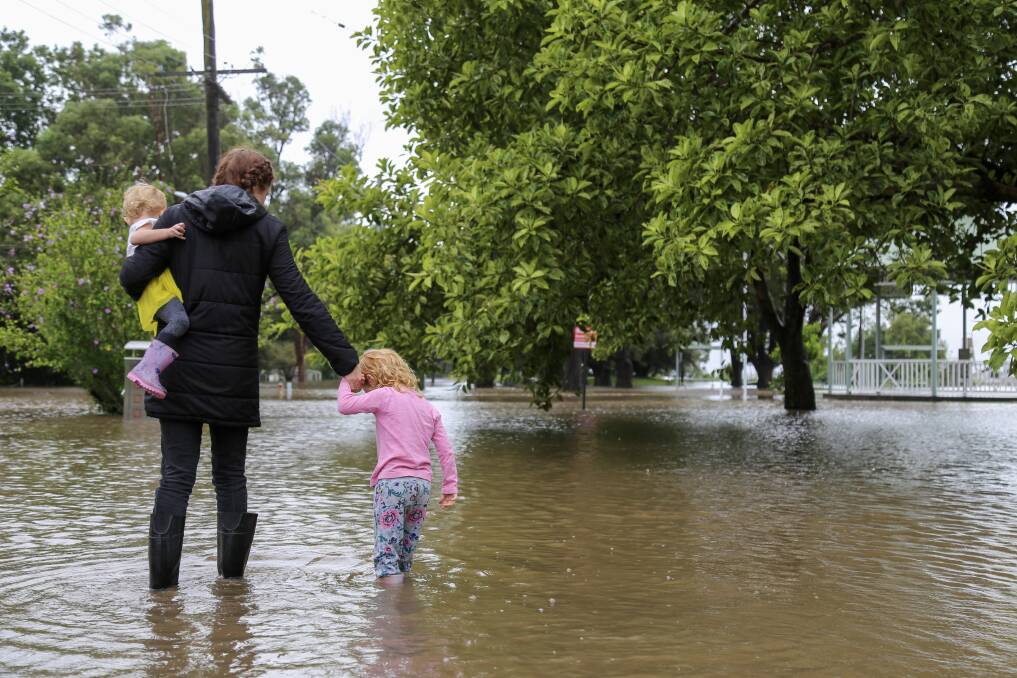 CURIOUS: A mother and her children check out the flooding in Riverside Park, Raymond Terrace on Sunday. Picture: Ellie-Marie Watts
