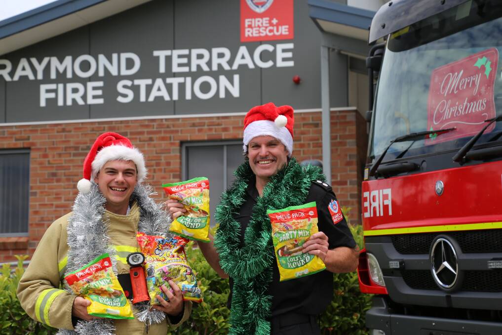 Raymond Terrace Fire and Rescue deputy captain Giacomo Arnott and firefighter Brett Hedley with some of the large bags of lollies that firefighters spend weeks dividing up into 5000 smaller bags to hand out to children on the lolly run. Picture: Ellie-Marie Watts