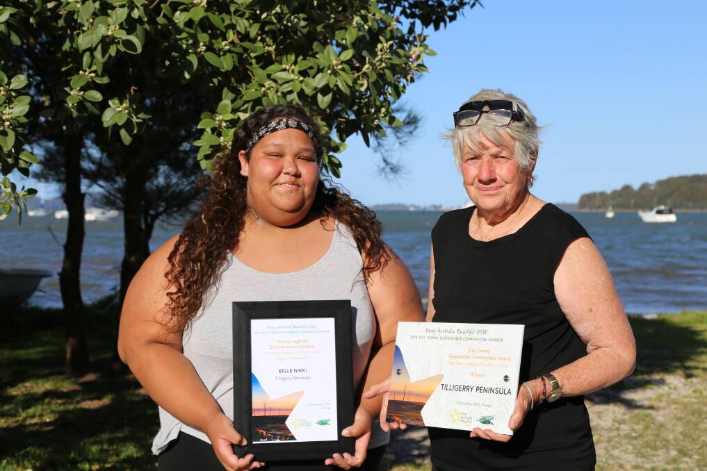 GOOD SHOW: Tanilba Bay's Belle Niki, 15, and Fran Corner, president of Tilligerry Landcare Group, with two of five 2018 Tidy Towns Sustainable Communities Awards. Picture: Ellie-Marie Watts