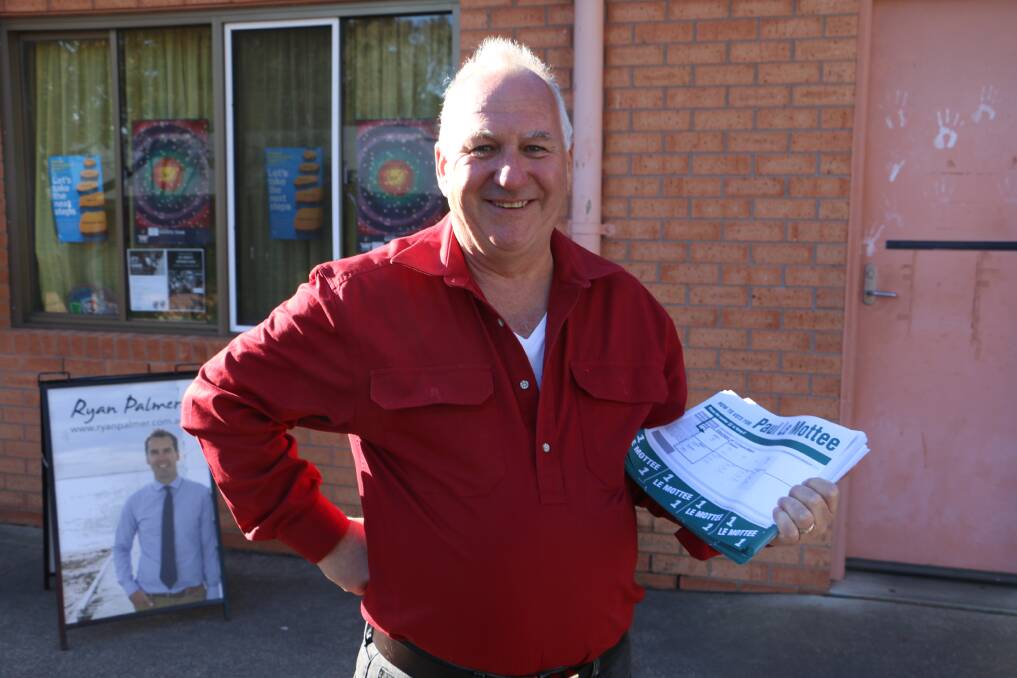 Paul Le Mottee handing out how to vote cards at Irrawang High School on election day in 2017.