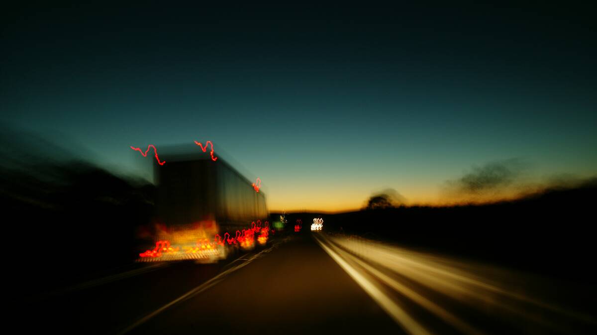 Stock image of a truck on Nelson Bay Road at night.
