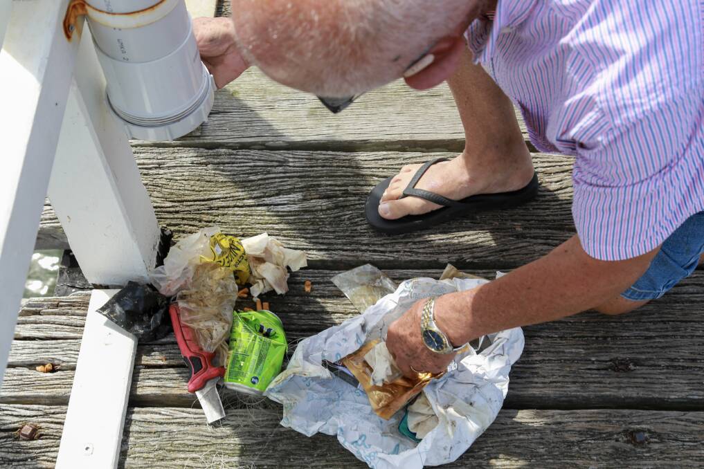 Hugh Mountford collecting rubbish from the fishing waste disposal pipe located at the end of Soldiers Point jetty, near to the entrance to the private marina.