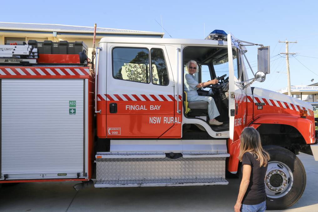 STILL GOT IT: Vera Sosso behind the wheel of Fingal Bay Rural Fire Brigades truck. Looking on is Sandy Nunn. Vera was one of the brigade's only female truck drivers back when she joined in the 70s. Picture: Ellie-Marie Watts
