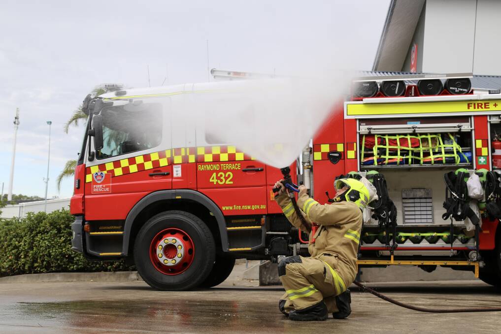 SAFETY FIRST: Raymond Terrace Fire and Rescue acting deputy captain Bernie Viemeier testing one of the truck hoses outside the station in Leisure Way. Picture: Ellie-Marie Watts