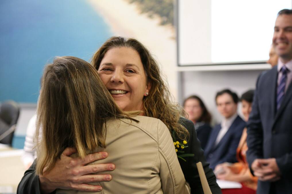 Port Stephens councillor Sarah Smith embraces Julie Jennings as she presents her with an Australian citizenship certificate in Raymond Terrace on Monday morning. Picture: Ellie-Marie Watts
