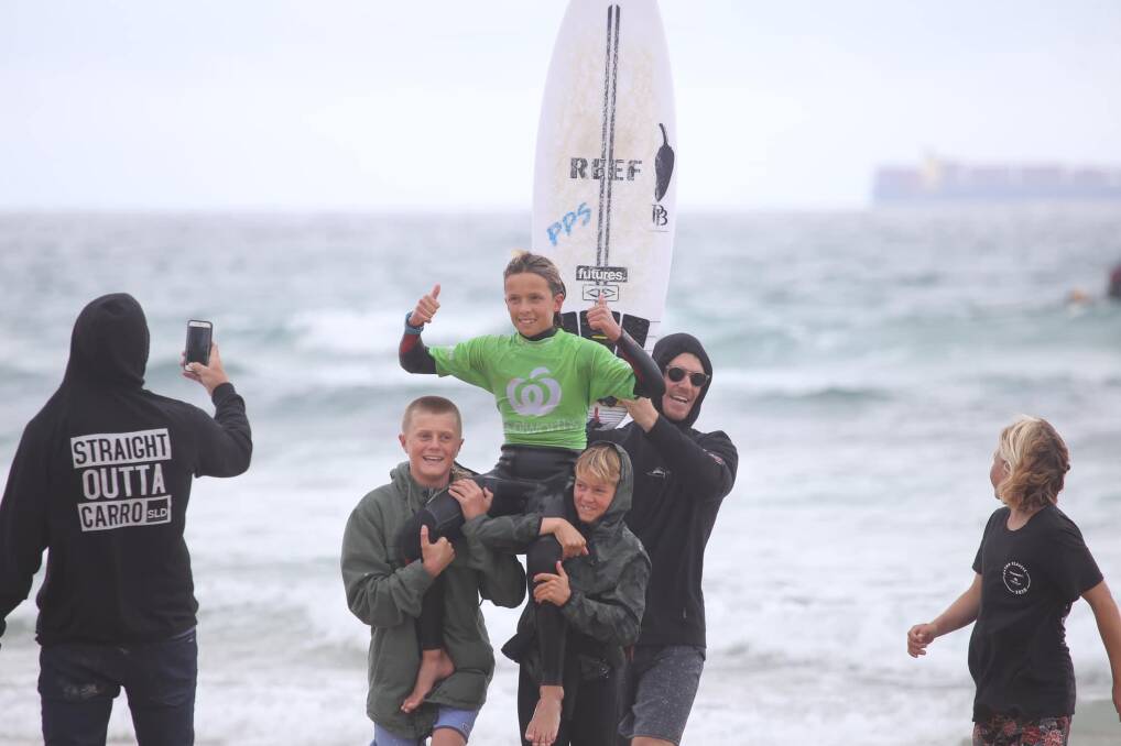 Eden Hasson hoisted in the air after winning the under-16 boys NSW Junior Shortboard State Title.