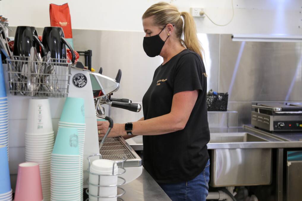 Kylie Gurr making a coffee in the kitchen of Fighter Beans Cafe, Williamtown. 