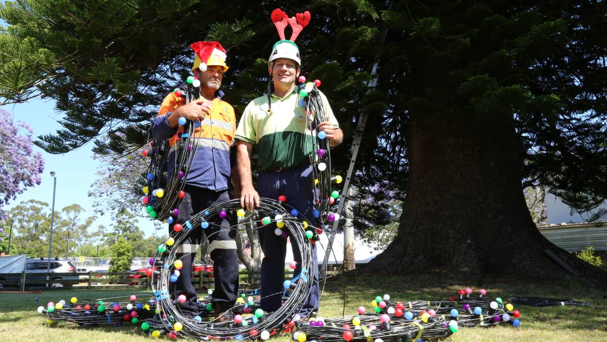 Port Stephens Council electrician Jamie Kemp with Dwayne Hopper installing the Christmas lights on December 20. Picture: Ellie-Marie Watts