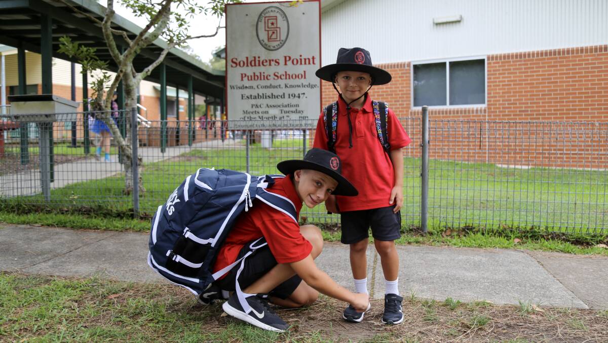 BIG DAY: Alexander Ford, 11, helping his younger brother Anthony Ford, 5, with his shoe before his first day of school at Soldiers Point Public on Monday.