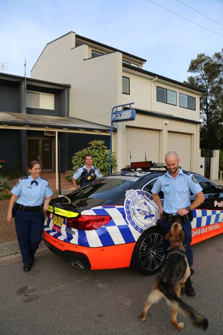 Acting Inspector Kristin Marshall, Senior Constable Peter Boys and Constable Luke Withers greeting a neighbourhood dog.