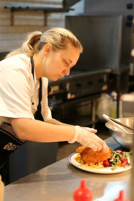 YUM: Schnitzels are back on the menu at Seabreeze Hotel in Nelson Bay. Pictured is chef Jessie Inskip plating up a meal on May 15, when the hotel opened it doors back up to the public.