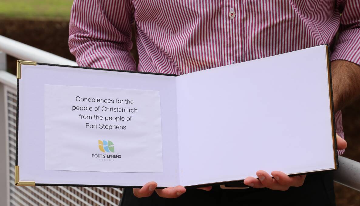 Port Stephens Mayor Ryan Palmer with one of the condolence books that will be available at libraries and the council administration building for residents to sign. Picture: Ellie-Marie Watts